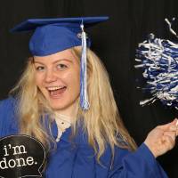 soon to be graduate takes a fun picture with photo booth props